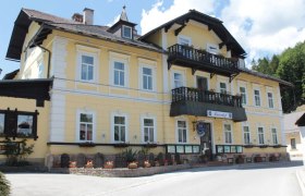 Gelbes Gebäude mit Balkon und Blumenkästen, Land-Pension Kaiserhof.