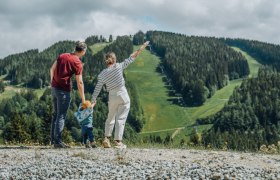 Familie blickt auf bewaldeten Berg am Semmering.