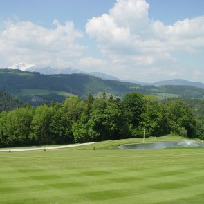 Golfplatz mit Reich und B&auml;umen, h&uuml;gelige Landschaft im Hintergrund
