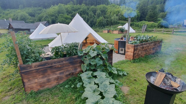 Glamping-Zeltplatz mit Feuerstelle und Hot Tub in gr&uuml;ner Umgebung.