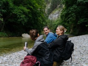 drei Wander:innen sitzen am Fluss im Höllental, © NÖW_Robin Uthe