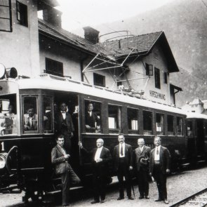 historische Aufnahme in schwarz-wei&szlig; der H&ouml;llentalbahn, davor stehen M&auml;nner und dahinter ist ein Haus