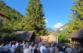 Freilufttheater in Nasswald mit Zuschauern und Bergkulisse.