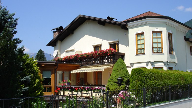 Wei&szlig;es Haus mit Balkon und Blumen