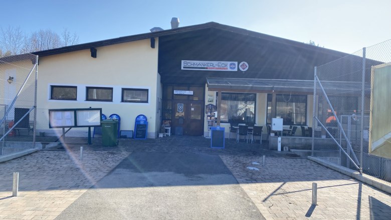 Au&szlig;enansicht eines Geb&auml;udes mit dem Schild 'Schmankerl-Eck'.