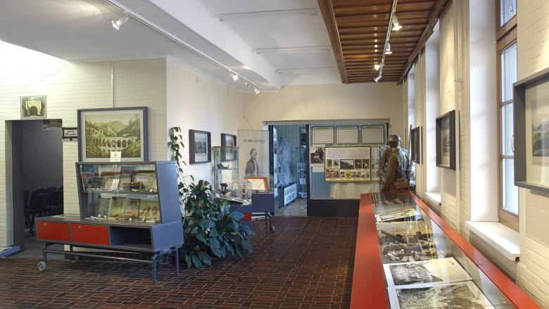 Innenansicht des Weltkulturerbe Infozentrums am Bahnhof Semmering mit Ausstellungsst&uuml;cken und Informationstafeln.