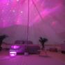 Innenansicht eines glamping Zeltes mit rosa Beleuchtung und gem&uuml;tlicher Einrichtung.