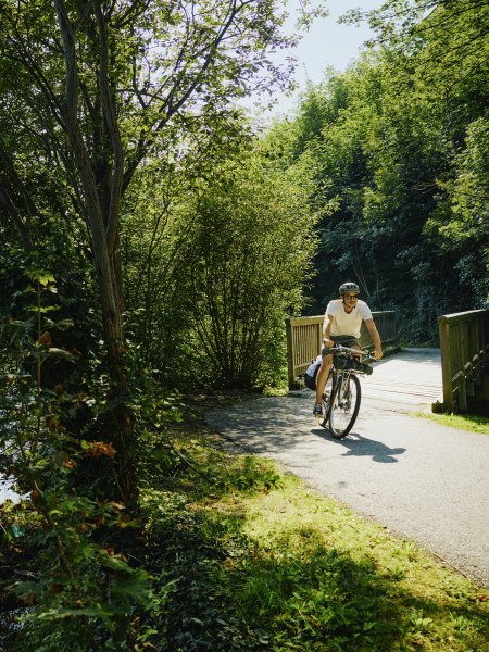 Mann auf der Schwarzatalerradweg fährt nach einer Brücke