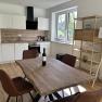 Moderne Küche mit Holztisch, Stühlen und Regal.