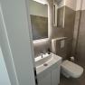 Modernes Badezimmer mit Waschbecken, Spiegel und Toilette.