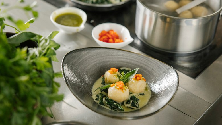 Knödel schön angerichtet neben einer Herdplatte und einem Topf