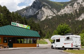 Wohnmobil vor dem Rax Park'n'Camp Gebäude mit Bergkulisse.