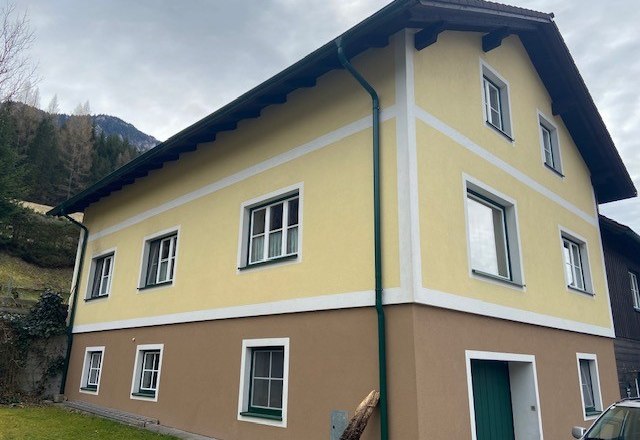 Hausansicht Privatzimmer Jansch, © Wiener Alpen Zweistöckiges gelb-braunes Haus mit weißen Fensterrahmen und grünem Fallrohr.