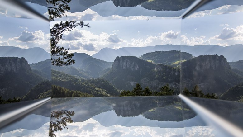 Blick durch einen Viewer auf eine hügelige bewaldete Landschaft.