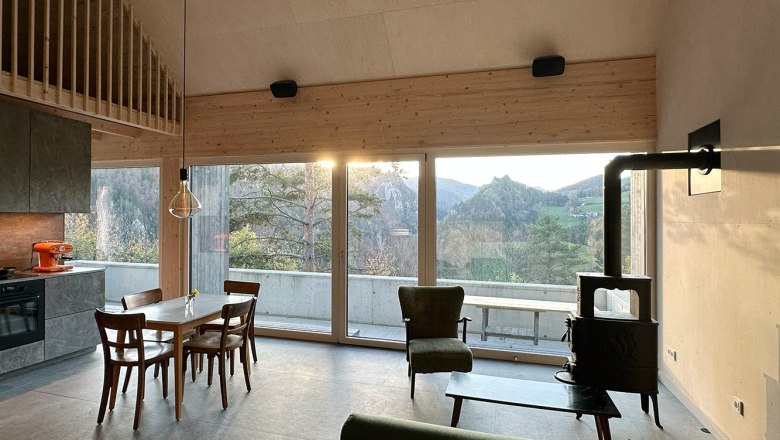 Moderner Wohn- und Essbereich mit großen Fenstern und Bergblick.