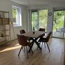 Esszimmer mit Holztisch, braunen Stühlen und Blick auf Terrasse und Garten.