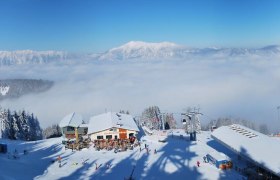 Panoramaausblick vom Hirschenkogel mit Liechtensteinhaus, im Hintergrund ist Rax, Schneeberg und Hohe Wand zu sehen.