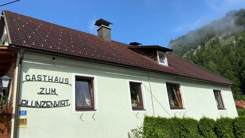 Außenansicht des Gasthauses Zum Blunzenwirt mit grünem Anstrich und braunem Dach.