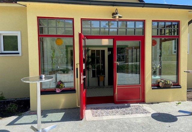 Eingang eines Gebäudes mit roten Tür- und Fensterrahmen.