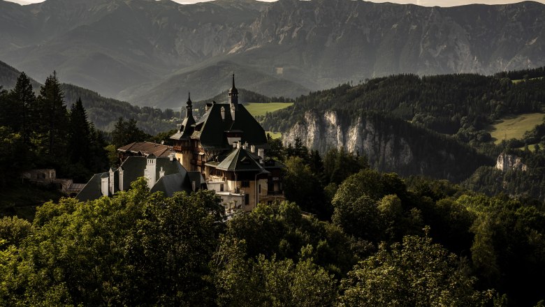 Blick auf ein historisches Hotel umgeben von Berglandschaft