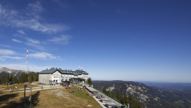Berggasthof auf der Raxalm mit Aussicht auf die umliegenden Berge und Täler.