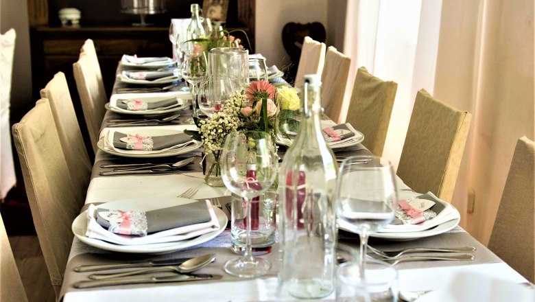 Festlich gedeckter Tisch mit Blumen und Geschirr im Höblinghof.