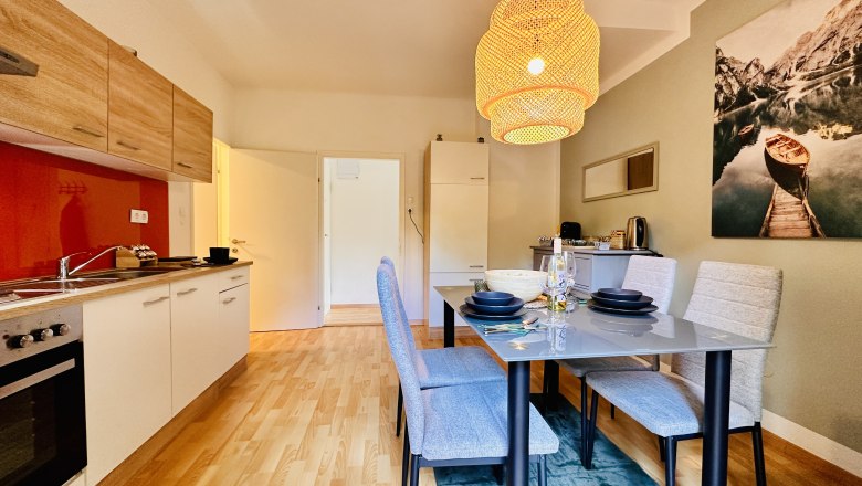 Moderne K&uuml;che mit Esstisch und H&auml;ngelampe.