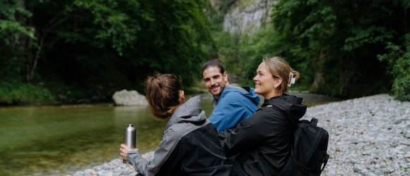 drei Wander:innen sitzen am Fluss im Höllental, © NÖW_Robin Uthe
