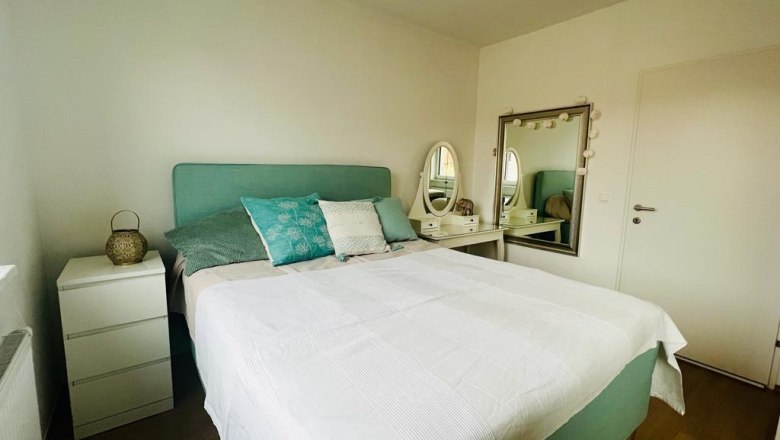 Schlafzimmer mit Doppelbett, Nachttisch und Schminktisch mit Spiegel.