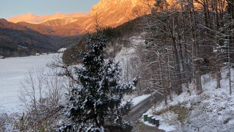 6d767414-dd04-425f-8cf1-08e1ec4fe488, © Martin Sturm Verschneite Landschaft mit Bergen im Hintergrund, die von der Abendsonne beleuchtet werden.