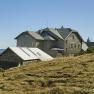 Berglandschaft mit dem Ottohaus und Wanderern auf einem Pfad.