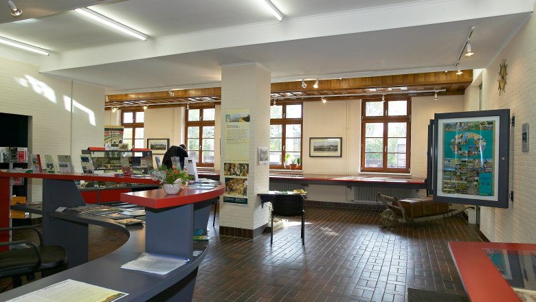 Innenansicht eines Museums mit Ausstellungsstücken und Informationsmaterial.