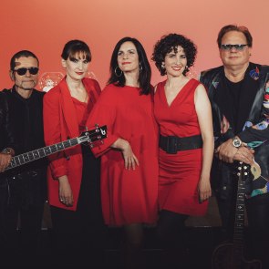 Schick Sisters & Opus, &copy; sieben Musiker einer Band stehen nebeneinander ein schwarz und roter Kleidung