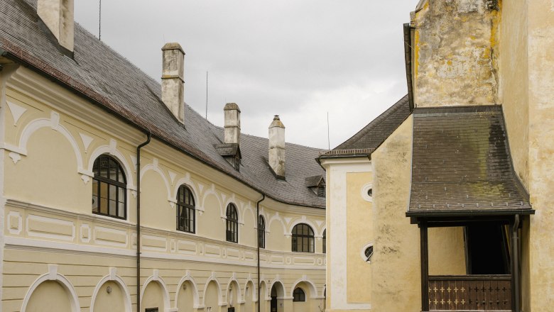 Historisches Gebäude mit gelber Fassade und Rundbogenfenstern, Gloggnitz.