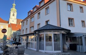 Au&szlig;enansicht eines Restaurants mit der Aufschrift 'Cult Italia' und einem Kirchturm im Hintergrund.