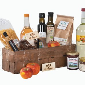 l&auml;nglicher Korb gef&uuml;llt mit regionalen Spazialit&auml;ten wie Fruchts&auml;fte, Marmeladengl&auml;ser, Nudel und mehr