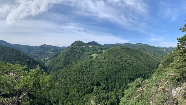Panoramablick auf bewaldete Hügel und blauen Himmel nach Semmering