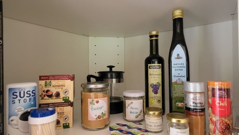 Vorratsschrank mit Gewürzen, Ölen und Kaffee.