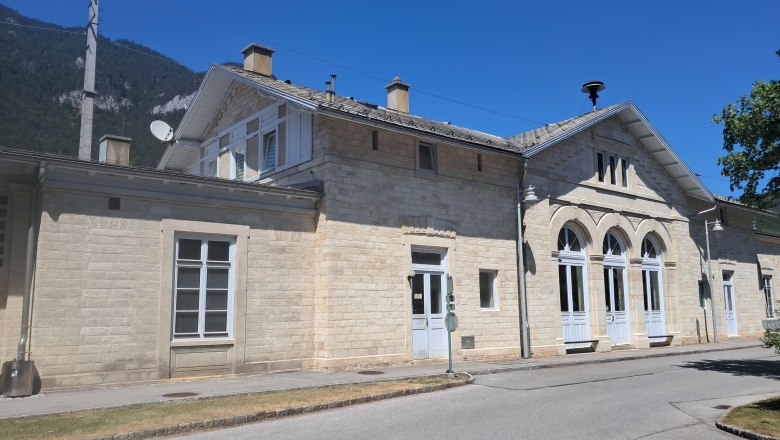 Bahnhof Payerbach-Reichenau mit historischem Gebäude und blauen Himmel.