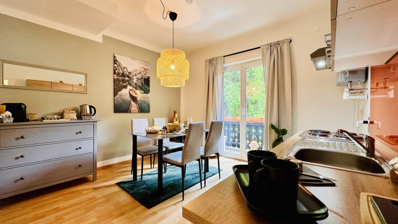 Gem&uuml;tliches Apartment mit Esstisch, K&uuml;chenzeile und Balkon.