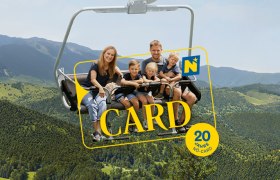 Eine Familie auf dem Sessellift. Die NÖ Card wird beworben.