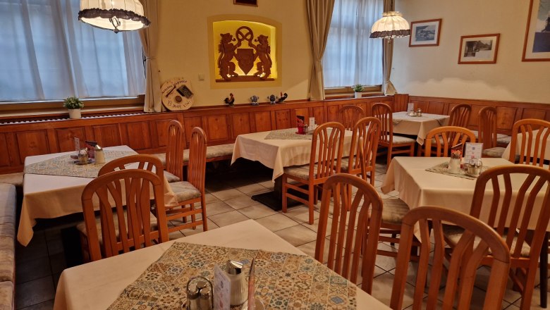 Gem&uuml;tliches Caf&eacute; mit Holzm&ouml;beln und dekorierten Tischen.