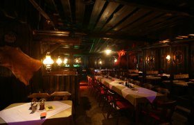 Rustikales Restaurant mit Holzmöbeln und gedämpfter Beleuchtung.