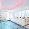 Moderner Wellnessbereich mit kleinem Pool, Pflanzen und ruhiger Atmosphäre.